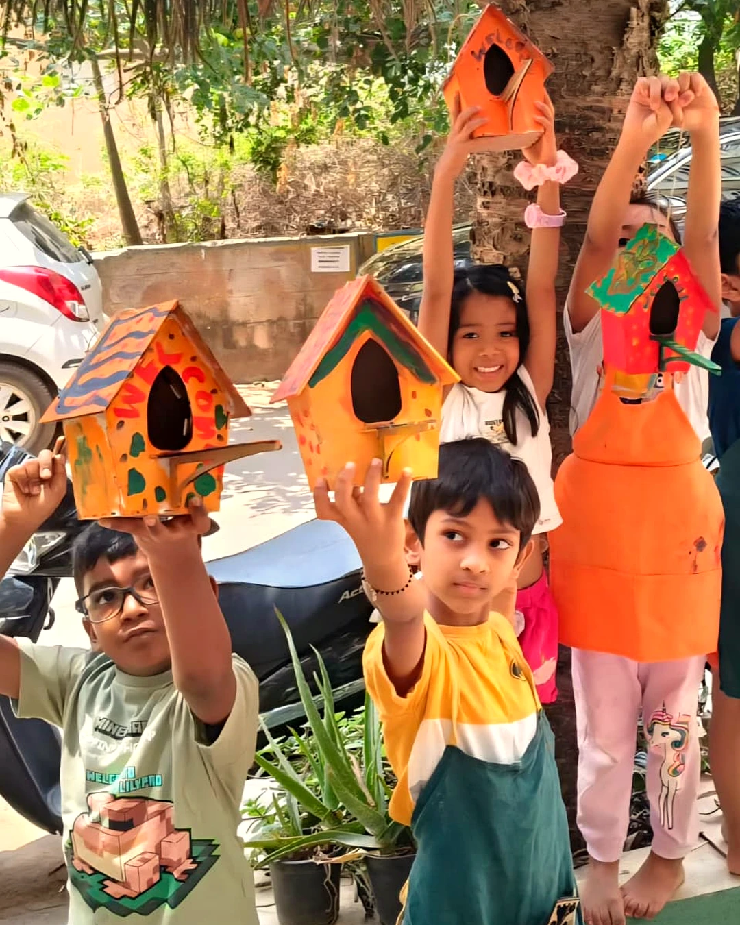 Children showing painted birdhouses at BOB